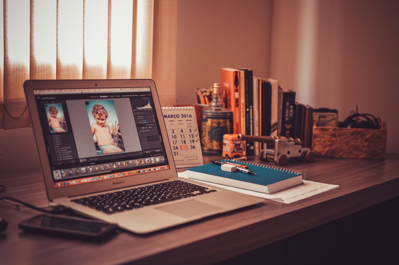 Warm-toned home office desk with a laptop, notebook, and books. Perfect for freelancers.